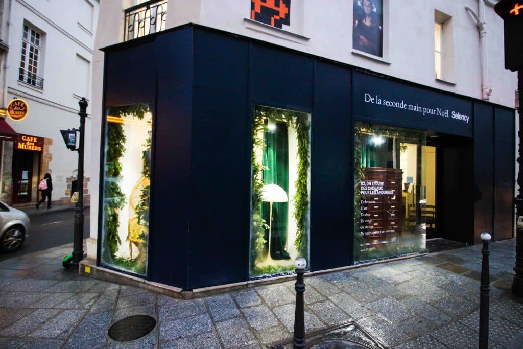Vitrine d'un pop-up store dans le Marais à Paris attirant les visiteurs grâce à une mise en scène soignée.