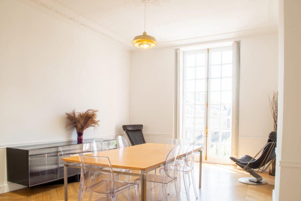 Cuisine lumineuse avec étagères en bois et mobilier moderne dans un appartement haussmannien Place des Vosges